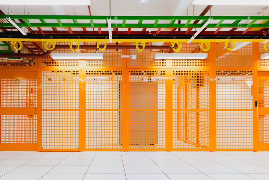 Orange private client cages and overhead infrastructure at SuperNova